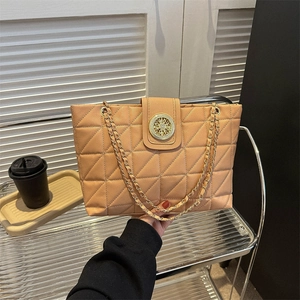 Sac fourre-tout matelassé marron minimaliste avec pendentif doré sur support métallique
