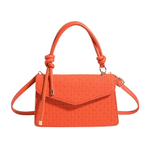 Sac à bandoulière orange à texture tissée avec poignée ronde épaisse sur fond blanc épuré