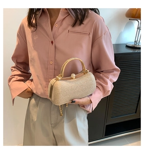 Dettaglio di una pochette da sera intrecciata oro champagne con manico in strass