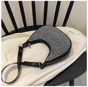 Detail of trendy black hobo bag with sparkling rhinestones and silver chain accents