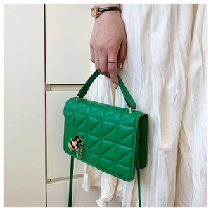 Detail of bright green quilted handbag featuring golden twist lock and chain handle