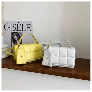 Detail of yellow and white quilted handbags with matching mini coin purses and straps