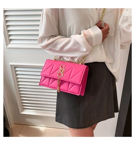 Detail of rose pink crossbody bag with diamond quilting and gold SS logo tassel