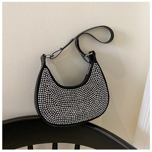 Detailed macro shot of silver rivets on a black crescent-shaped hobo shoulder bag