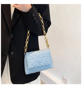 Close-up of light blue quilted PU leather shoulder bag with thick gold acrylic chain