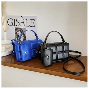 Detail view of quilted puffer tote bags in blue and black with matching mini pouch set