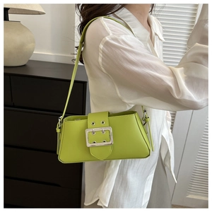 Detail of bright green underarm bag with large silver buckle on smooth PU leather strap