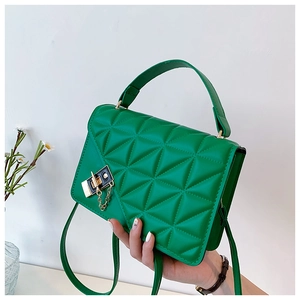 Detailed view of the bright green quilted bag with a gold chain buckle and fine stitching
