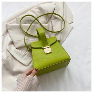 Détail du sac à main vert fluo texture crocodile avec boucle rectangulaire dorée