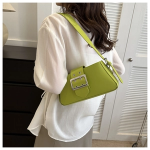 Detailed side view of a green underarm bag with a bold silver buckle for women