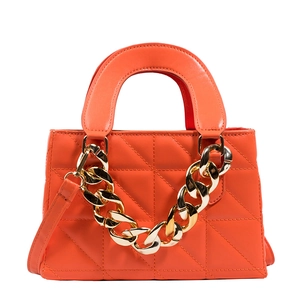 Quilted orange crossbody handbag with bold gold chain detail on white background