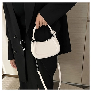 Detail of white half-moon bag featuring knot design, metal chain strap and logo texture