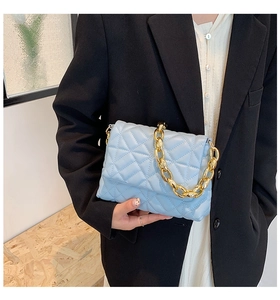 Close-up of sky blue quilted shoulder bag featuring chunky gold chain strap details