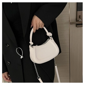 Close-up of white crescent bag with knotted handle and FASHION & BAGS embossed text