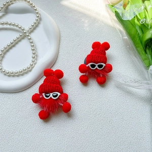 Detail of red plush monster phone sockets with knit hats and sunglasses on desk