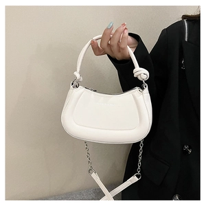 Detail of white half-moon crossbody bag with knotted handle and metal chain strap