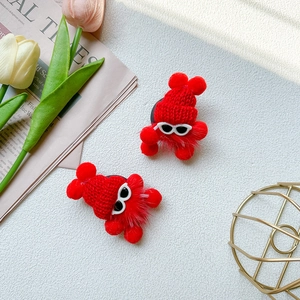 Close-up of cute red plush little devil phone stand with knit hat and sunglasses detail