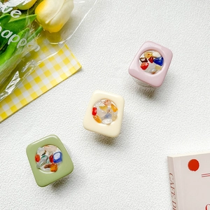 Pastel square phone grips with colorful natural stones on a white textured background
