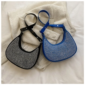 Top view of black and blue crescent underarm bags with silver studs and metal chain strap