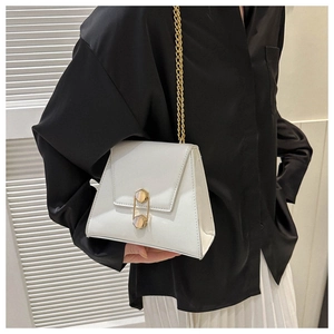 Close-up of a white trapezoid handbag with gold chain strap and hexagon metal lock