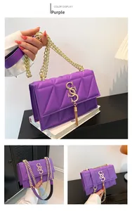 Detail of purple quilted leather crossbody bag with gold S-logo and chain strap