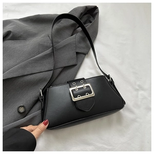 Detailed close-up of a black matte leather underarm bag with a bold silver metal buckle