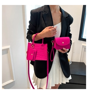 Close-up of three-piece magenta crocodile texture handbag set with elegant gold hardware