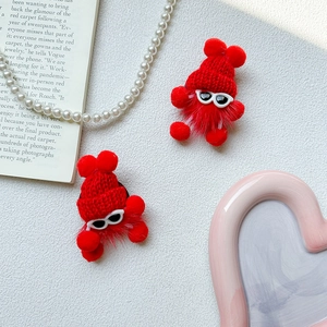 Detail of red plush little monster phone stand with cute knit hat and sunglasses