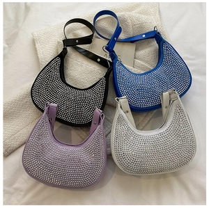 Flat lay of crystal crescent underarm bags in black, blue, purple, and silver colors