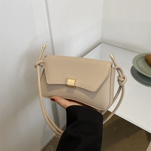 Minimalist beige baguette shoulder bag with gold square lock and knotted strap design