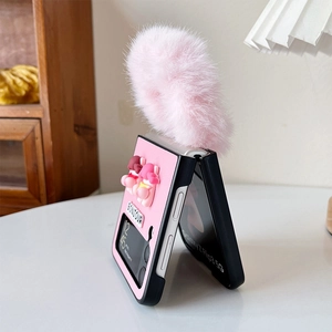 Detail of pink plush faux fur pompom and cartoon character on Samsung Z Flip case