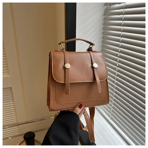 Detail of brown vintage faux leather backpack with gold hardware and top handle