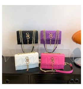 Detail view of quilted chain bags in multiple colors featuring stylish S-logo and tassels
