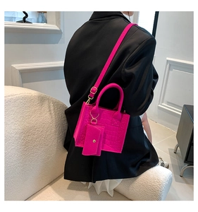 Detailed view of magenta crocodile pattern tote bag with mini decorative bag on strap