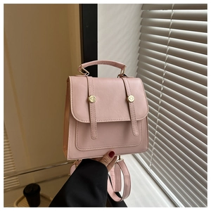 Detail view of pink PU leather backpack texture and gold round metal buckle design