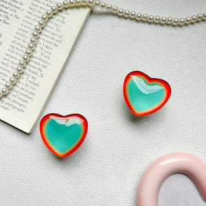 Detail of gradient heart-shaped phone grips on a stylish aesthetic background