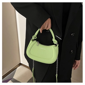Detail of light green hobo bag featuring knotted handle and silver chain strap