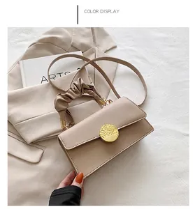 Détail du sac bandoulière kaki avec poignée froncée et boucle dorée texturée