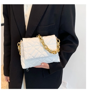 Detailed close-up of a white quilted PU leather handbag with a chunky gold chain strap