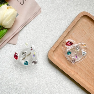 Macro shot of heart-shaped phone grip with colorful rhinestones and gold text