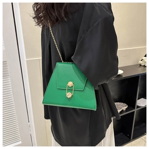 Model view of a lime green trapezoid chain bag with a gold double hexagonal lock