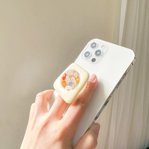 Cell phone grip socket with colorful crushed stones on a cream square base