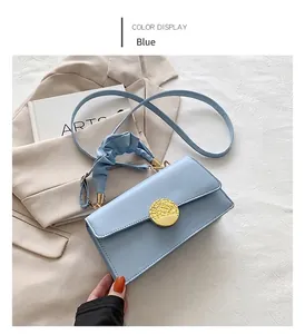 Détail du sac plissé bleu clair avec une boucle en métal doré et un aspect élégant