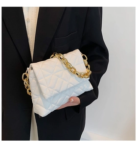 Close-up of a white quilted PU shoulder bag featuring a chunky gold acrylic chain strap