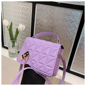 Detail of lavender quilted faux leather handbag with gold lock and chain on floral background