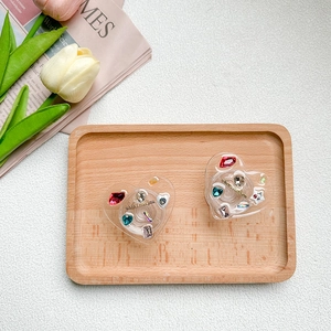 Close-up of heart-shaped rhinestone phone grips with 'when I met you' text on wood