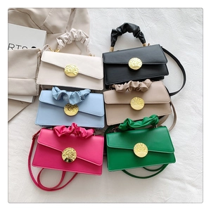 Flat lay of multiple stylish pleated handbags with golden metal buckles in six vibrant colors