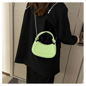 Detail of neon green crescent shoulder bag with silver chain strap and logo
