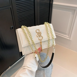 White quilted shoulder bag with gold logo pendant and chain strap in hand