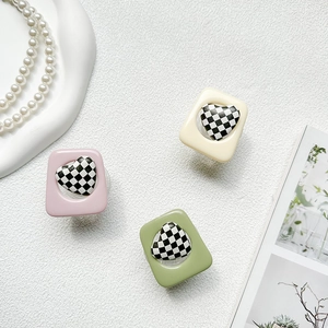 Macro detail of heart checkerboard phone sockets in pink, green, and cream colors